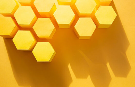 3D yellow hexagonal paper shapes arranged on a yellow background. Stocksy