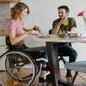 Happy couple eating breakfast, female in wheelchair