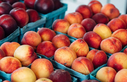Fresh peaches in baskets at a farmer's market stand