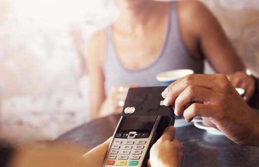 Cropped shot of a customer paying for coffee with a credit card at a cafe