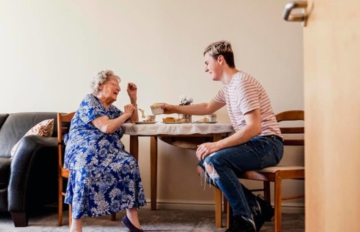 elderly woman and young man playing board game