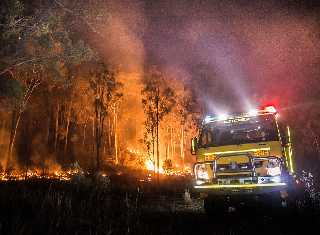Australian bush on fire with firetruck - istock